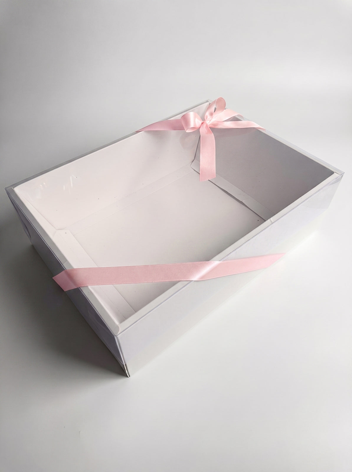 Boîte cadeau transparente et son ruban rose