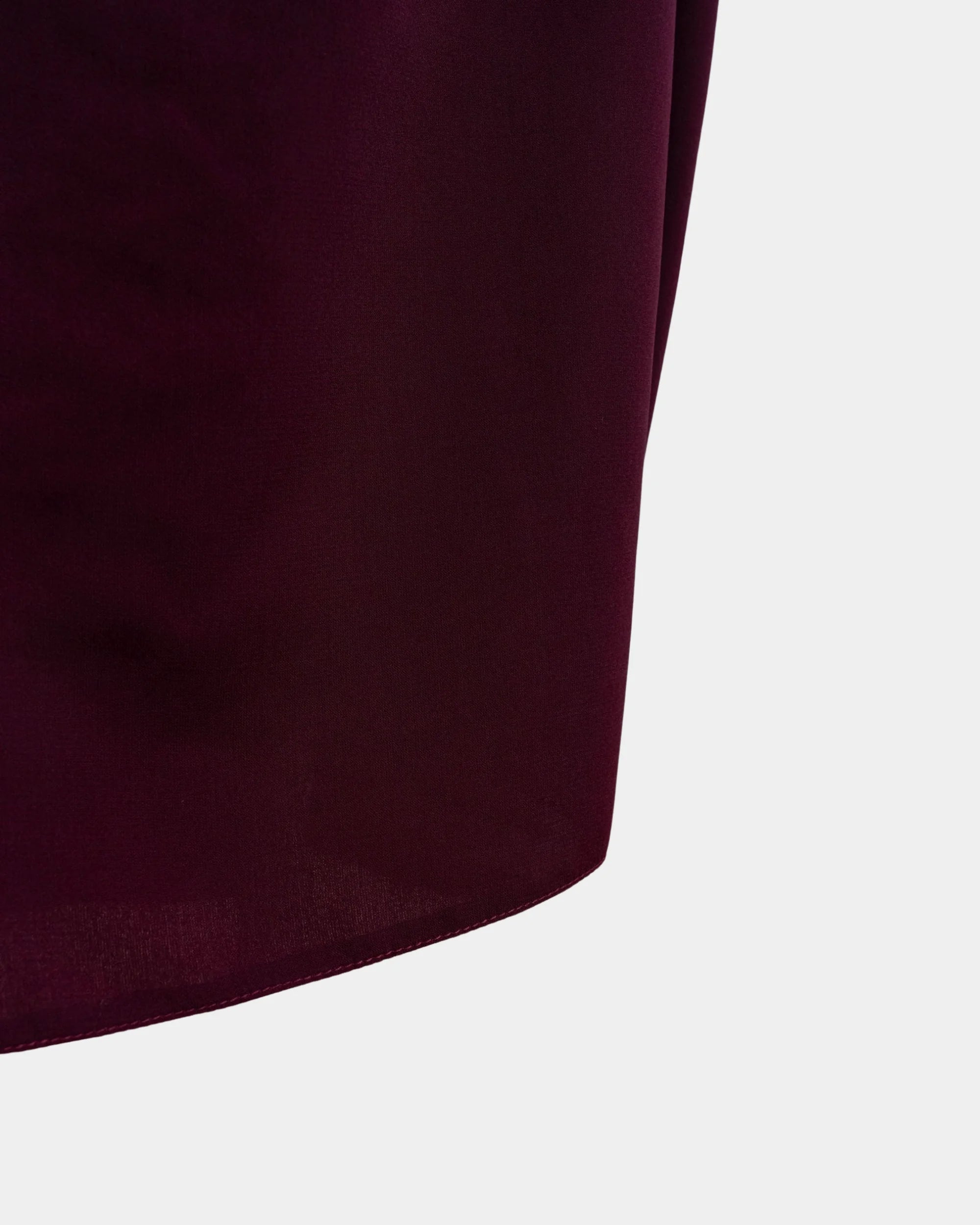 Bas du jilbab bordeaux, ourlet surpiqué et finition arrondie du tissu
