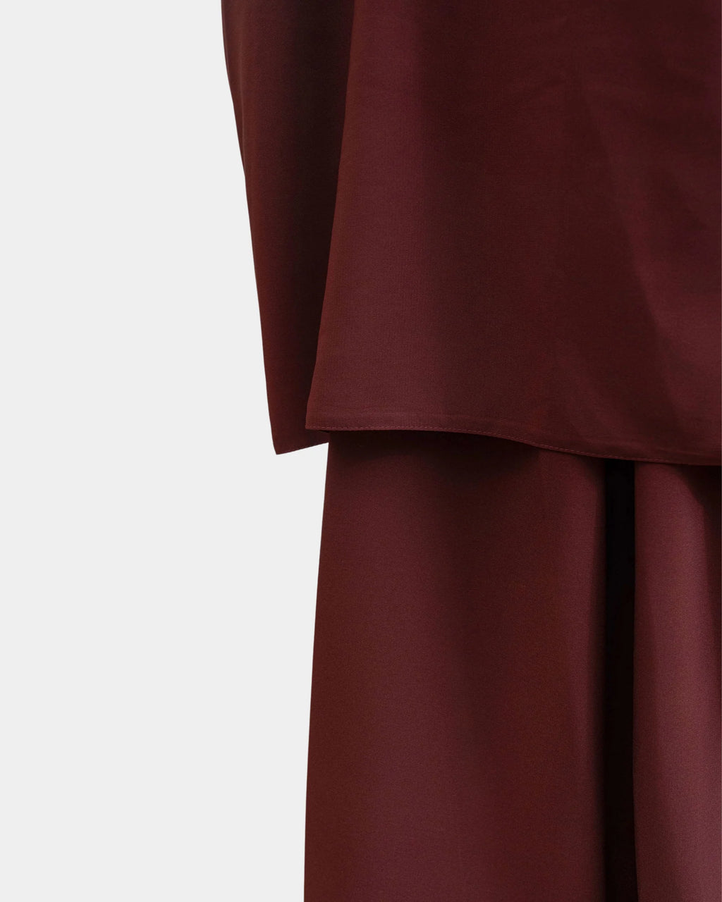 Ourlet du khimar rouille retombant sur la jupe assortie, finition surpiquée